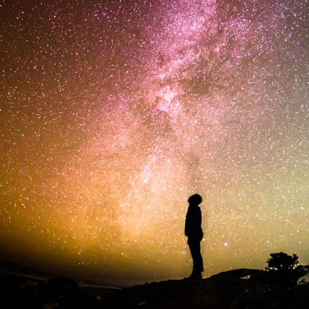 silhouette of a man looking at the night sky